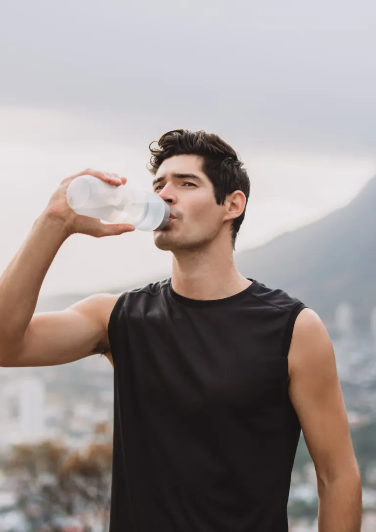 Athlete drinking water after training in a mountain setting