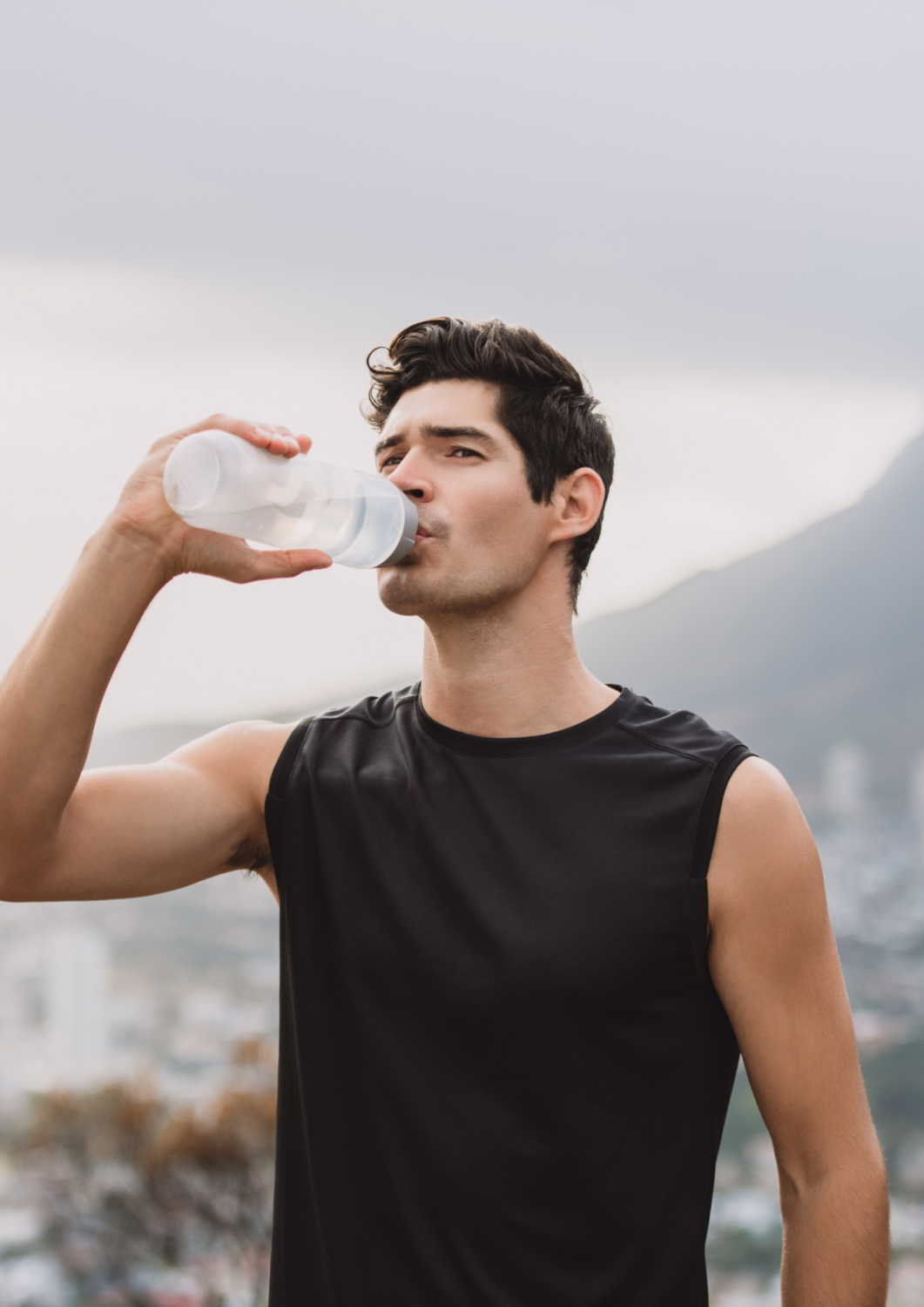 Athlete drinking water after training in a mountain setting