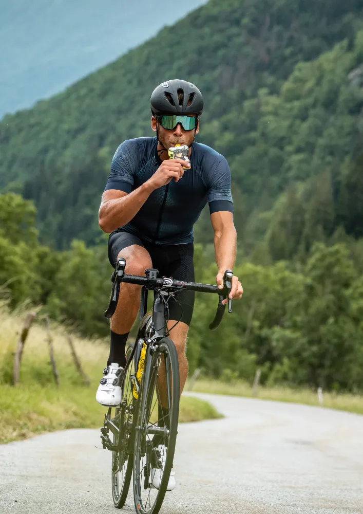 Cyclist using an Isostar energy gel during a long ride